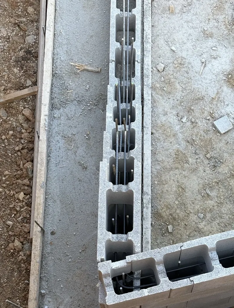 Angle de muret en agglos à bancher sur semelle béton, armatures verticales et horizontales en place avant coulage